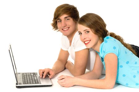 Young couple lying on floor using laptopの写真素材
