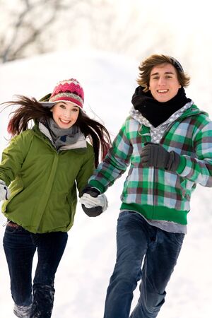 Couple running in the snowの写真素材