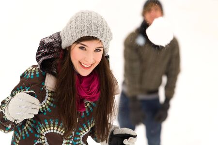 Couple having snowball fightの写真素材