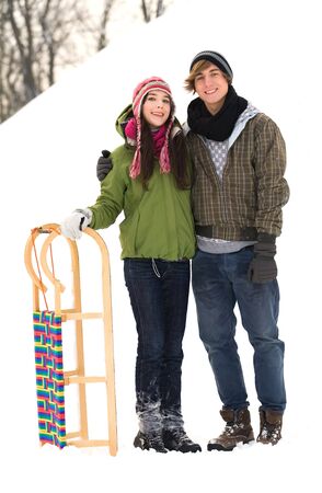 Couple standing in snow by sledの写真素材