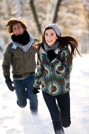 Couple running in the snowの写真素材