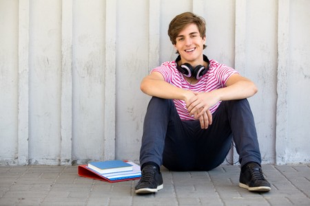 Young man sitting with booksの写真素材