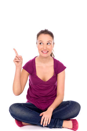 Cheerful young woman pointing upwardsの写真素材