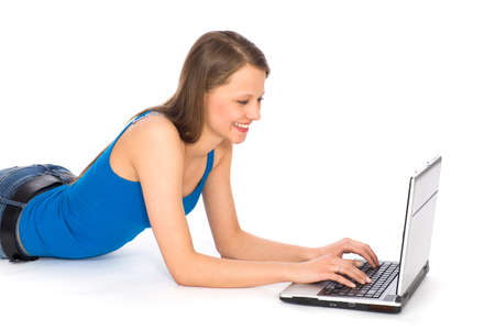 Young woman lying on floor using laptopの写真素材