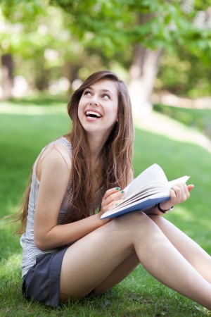 Young woman reading book outdoorsの写真素材