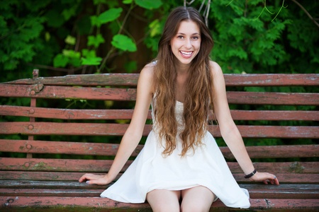 Woman sitting on a park bench の写真素材