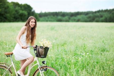 Woman on bicycle in fieldの写真素材