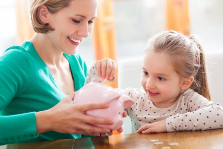 Mother and daughter with piggy bankの写真素材
