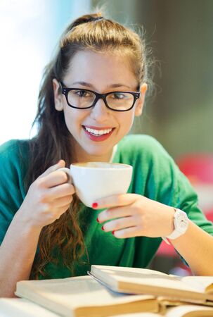 Female student with books and cup of coffeeの写真素材