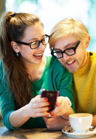 Couple text messaging in cafeの写真素材