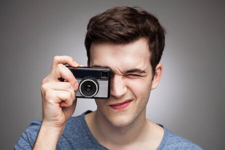 Young man with vintage cameraの写真素材