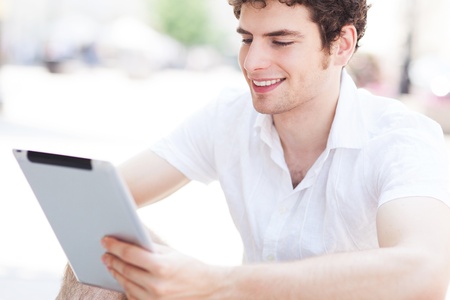 Young man using digital tablet outdoors