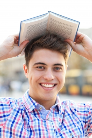 Young man with book over his headの写真素材