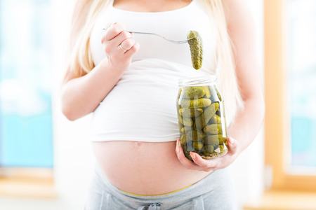 Pregnant woman eating picklesの写真素材