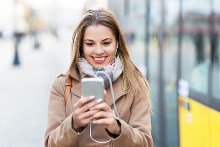Woman looking at texts on her smartphoneの写真素材