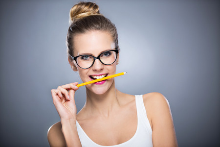 Woman biting a pencilの写真素材
