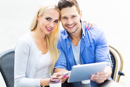 Couple using digital tablet at cafeの写真素材