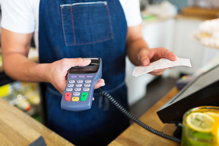 Waiter holding a credit card readerの写真素材