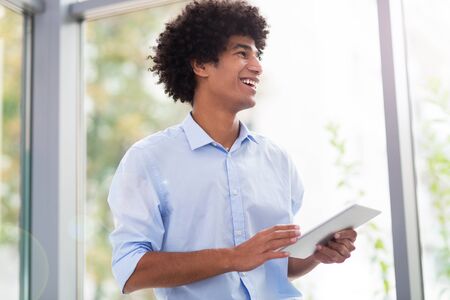 Man with afro holding digital tablet