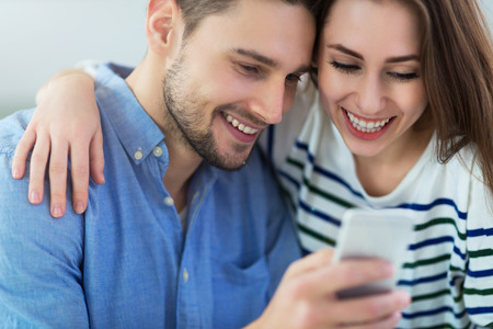 Couple using mobile phone togetherの写真素材