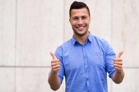 Young man showing thumbs up