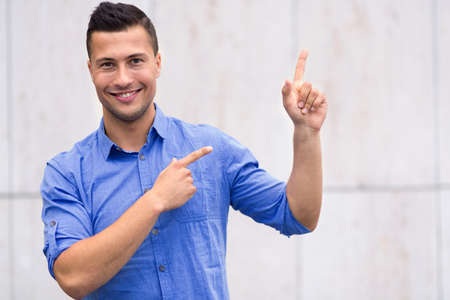 Young man pointing up