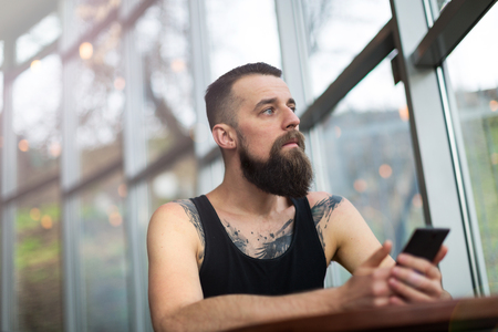 Young bearded man using mobile phoneの写真素材