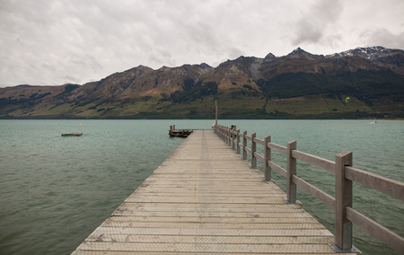 Jetty on a lake with mountain viewの写真素材