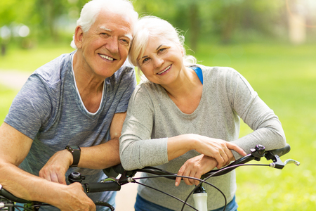 Senior Couple Riding Bikes In Parkの写真素材