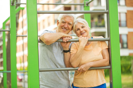 Senior couple exercising at outdoor gymの写真素材