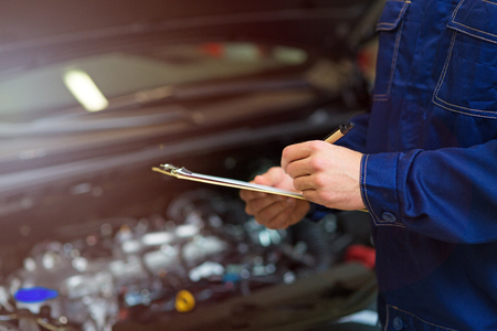 Mechanic working on the engine in auto repair shopの写真素材