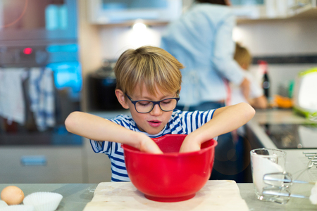 Boy helping mother in kitchenの写真素材