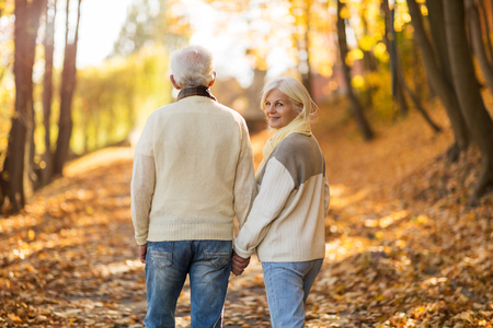 Elderly couple together in autumn parkの写真素材