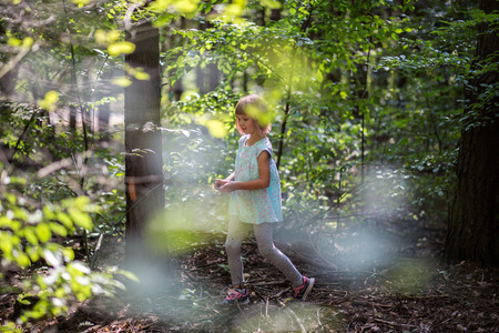 Little girl playing in the forestの写真素材
