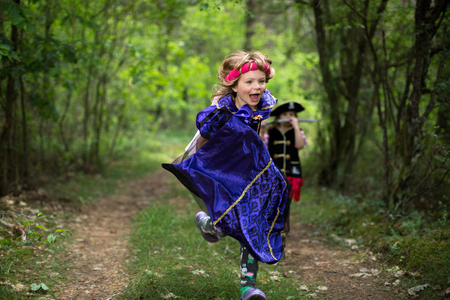Children playing in the forest wearing costumesの写真素材