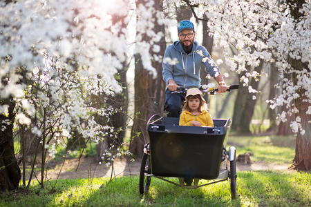 Father and daughter having a bike ride during springの写真素材