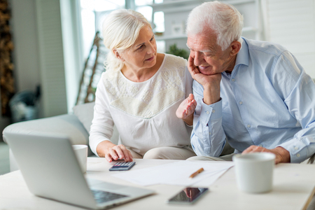 Senior couple using laptop computer at homeの写真素材