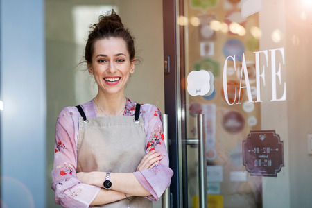 Woman standing in front of coffee shopの写真素材