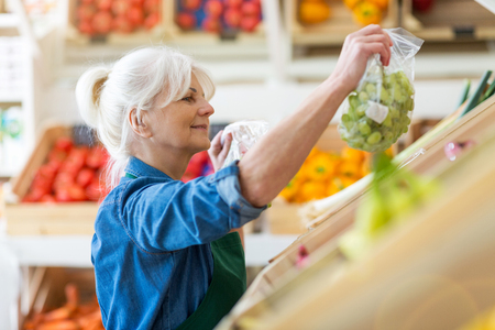 Portrait of woman in fruit and vegetable stallの写真素材