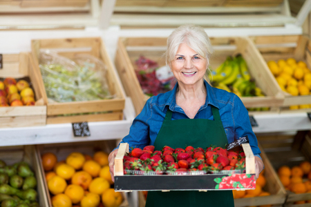 Portrait of woman in fruit and vegetable stallの写真素材