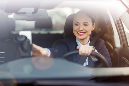 Happy woman driving a car and smilingの写真素材