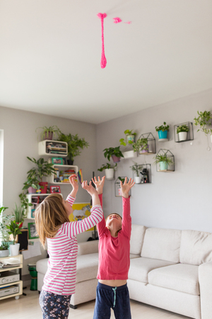 Little girls playing with slime toy hanging from the ceilingの写真素材