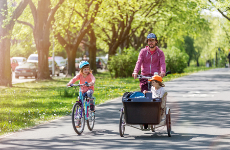Father and daughters having a ride with cargo bike during springの写真素材