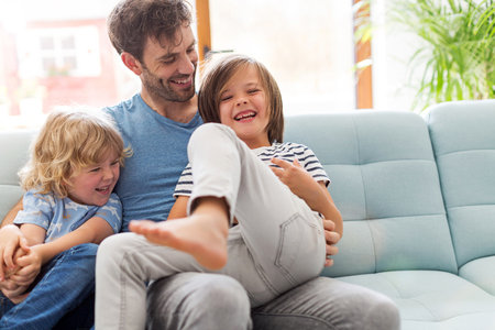 Father playing with his children at homeの写真素材