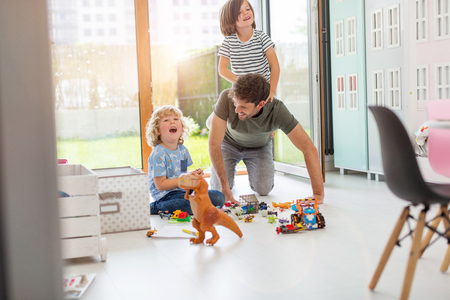 Father playing with his children at homeの写真素材