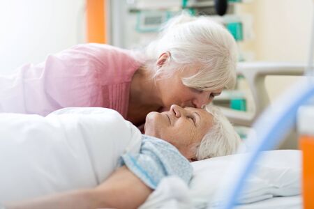 Daughter visiting her senior mother in hospitalの写真素材