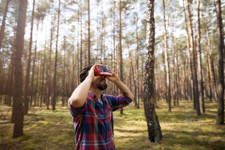 Man Wearing Virtual Reality Simulator While Standing In The Forest