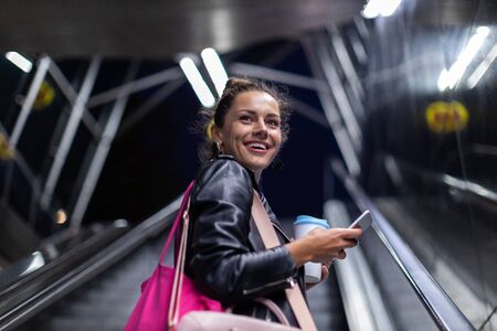 Young woman with smartphone at night in a urban city area