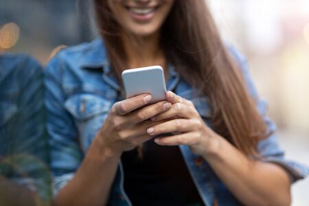 Young woman with smartphone in an urban city areaの写真素材