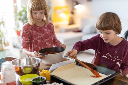 Children preparing pizza at homeの写真素材